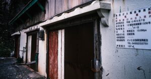 新島の古い倉庫・錆びた金属外壁と風化した木製扉