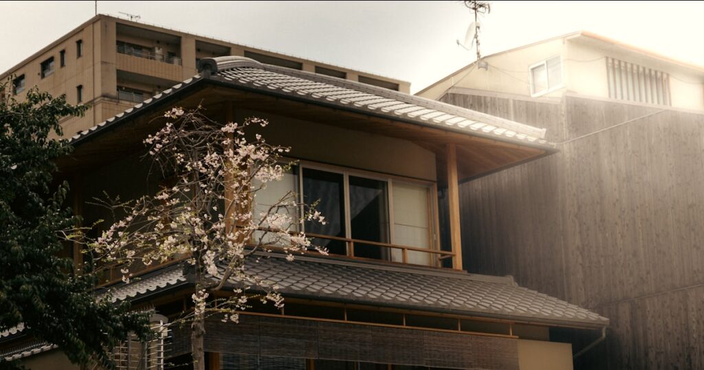 桜の花が咲く日本の伝統的な木造家屋の外観
